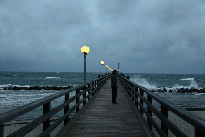 A wooden pier reaching into a grey Baltic Sea